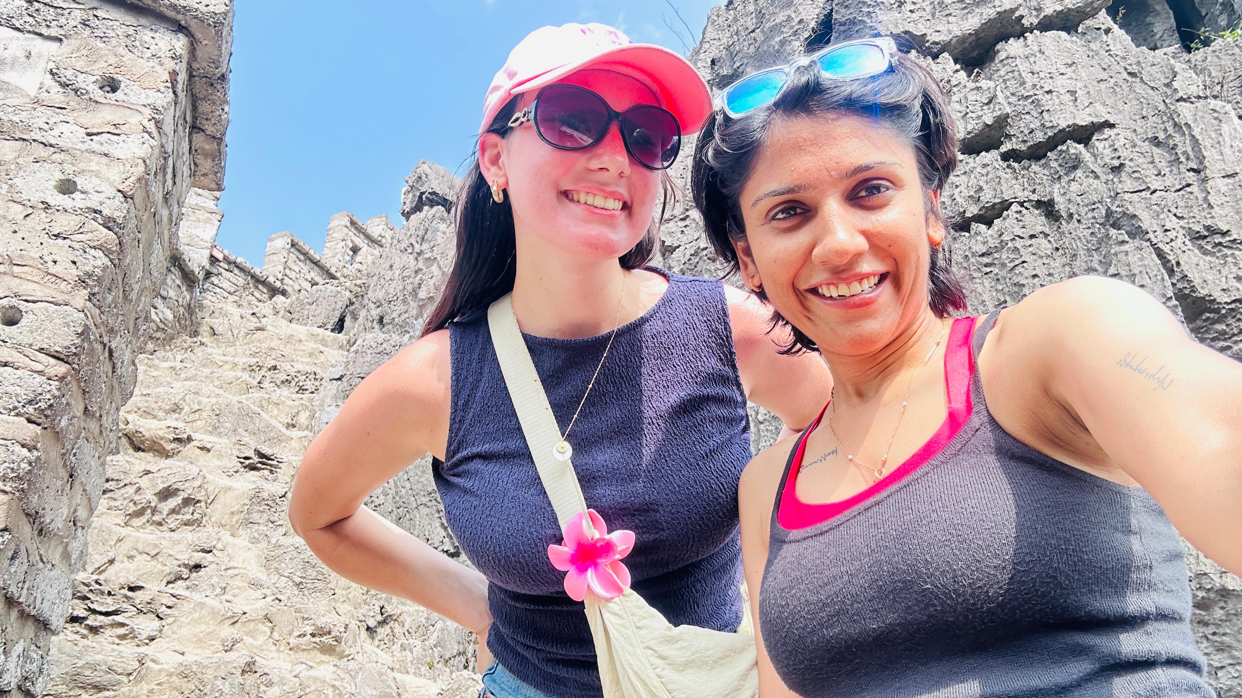 Suneha exploring ancient architectural stone ruins with foreign companion